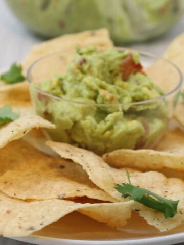 Guacamole with tortilla chips on a platter.