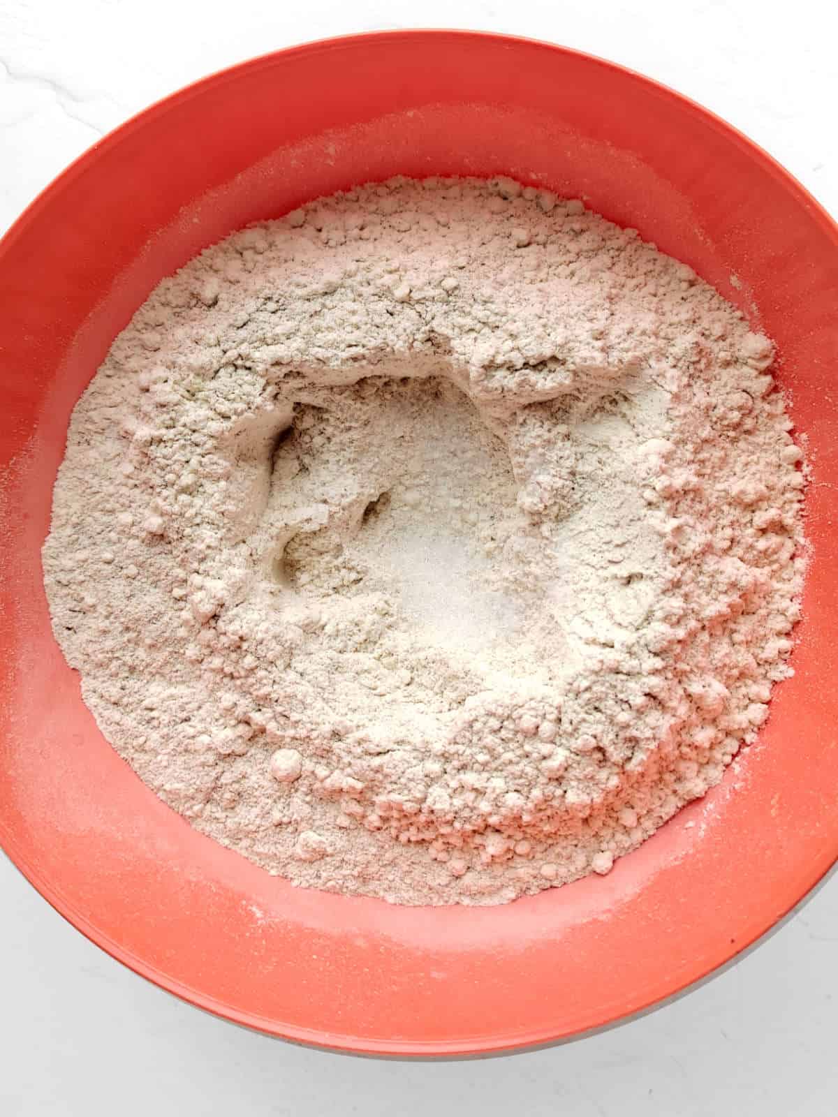 Flour and salt mixed in a bowl with a well in the center.