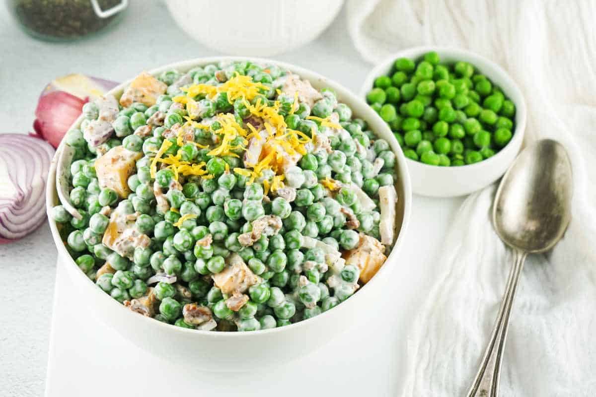 english pea salad in a bowl with grated cheese garnish.