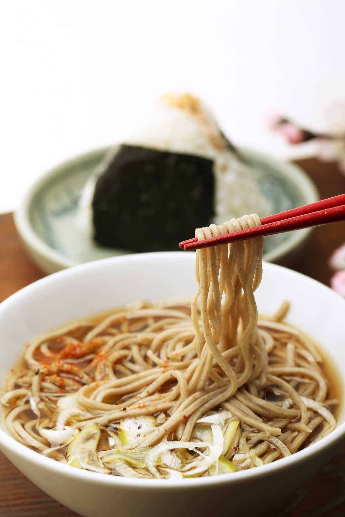 bowl of buckwheat noodles with spices sprinkled on top.
