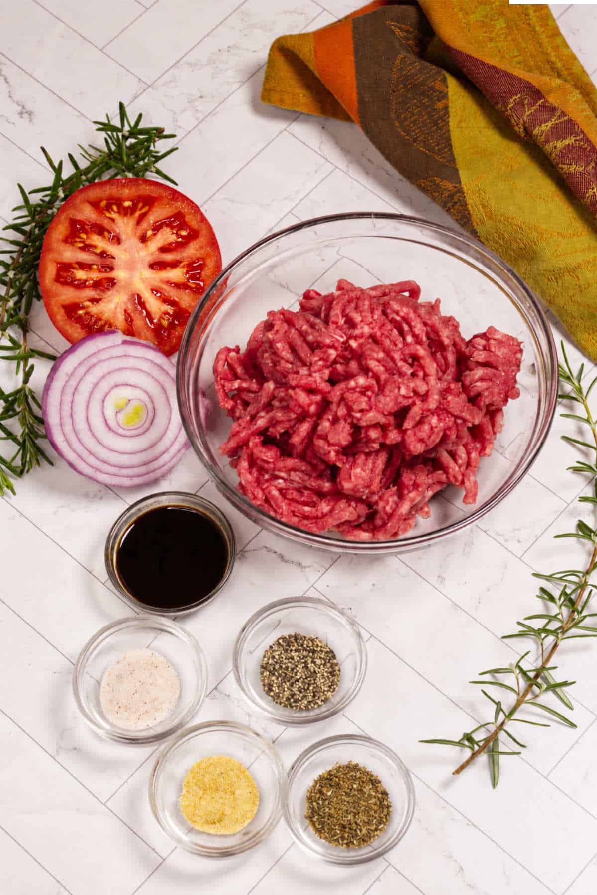 Ground lamb burger ingredients with dried Greek seasoning, garlic, salt, and pepper.