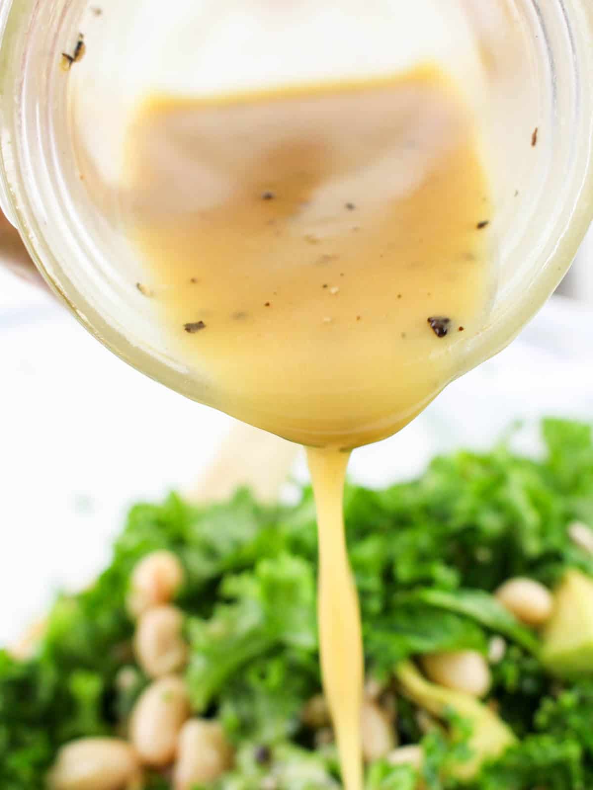 vinaigrette dressing being drizzled on a salad.