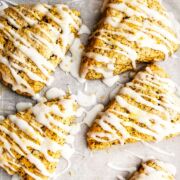 icing drizzled over baked wedge shaped lemon poppy seed scones.