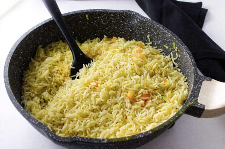 Cooked rice sautéed with onion and bell pepper for Longhorn rice pilaf.