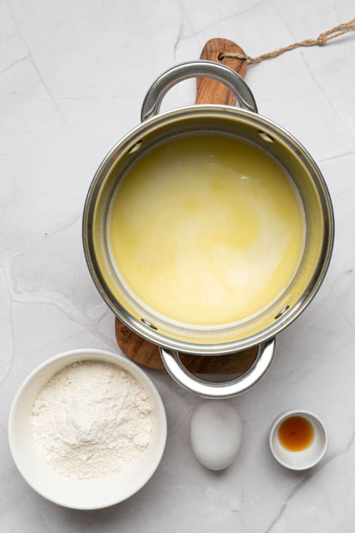 Water, butter, sugar, and salt heating in a saucepan for churro dough.