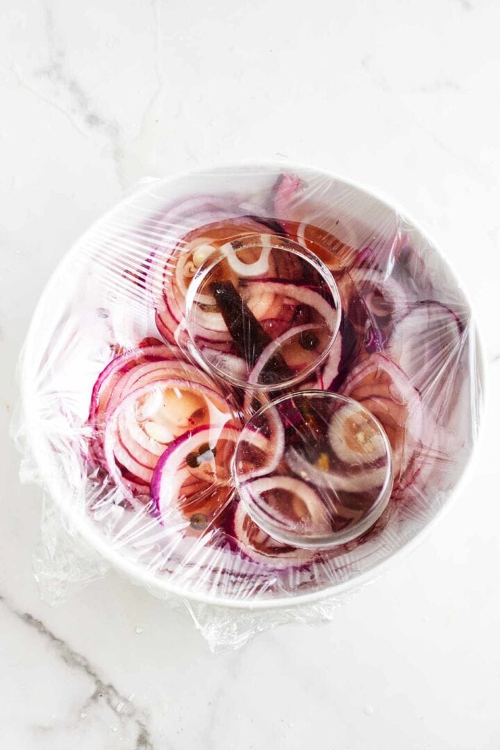Weights submerging sliced vegetables in brine.