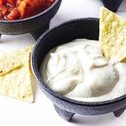 black bowls filled with tortilla chips, salsa, and Rango sauce.