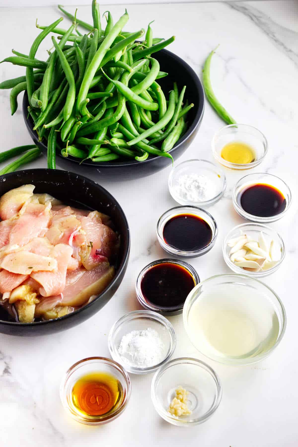 Ingredients for Panda Express String Bean Chicken with sliced chicken, green beans, garlic, onion, soy sauce, and stir fry sauce.