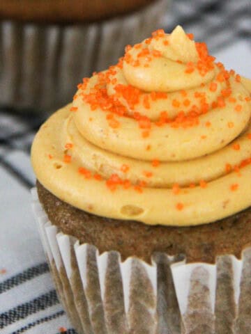peanut butter cupcakes with peanut butter frosting decorated with orange sugar.