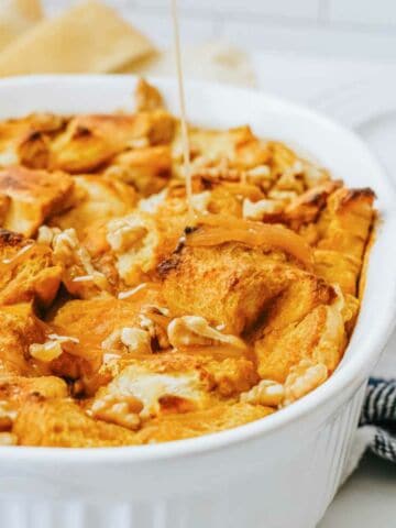 glaze drizzled on top of pumpkin bread pudding in a casserole dish.