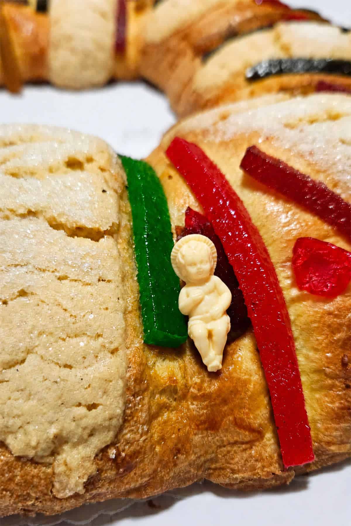 Finished Rosca de Reyes wreath decorated with white glaze, sliced almonds, and candied cherries.