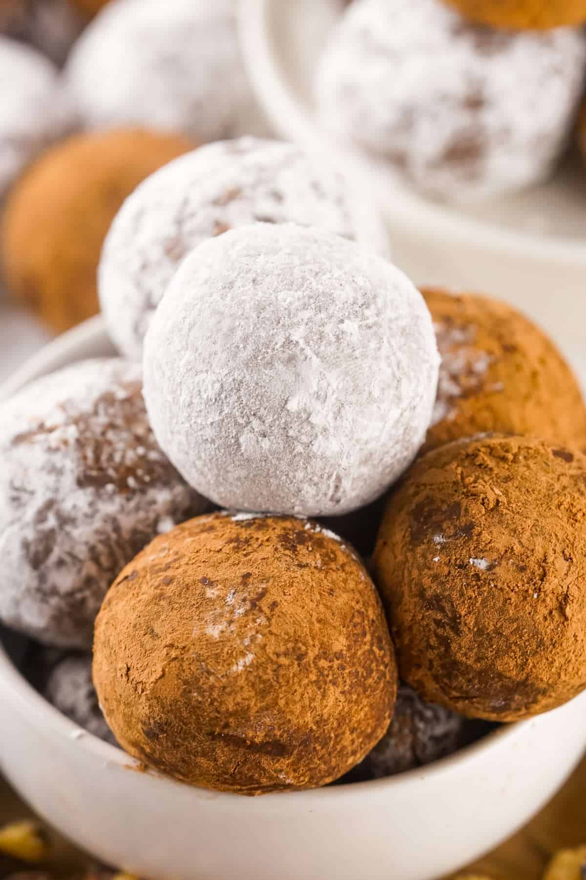 Serving plate with some chocolate rum balls stacked up.