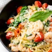 pasta tossed with cream sauce, shrimp, tomatoes, and spinach.