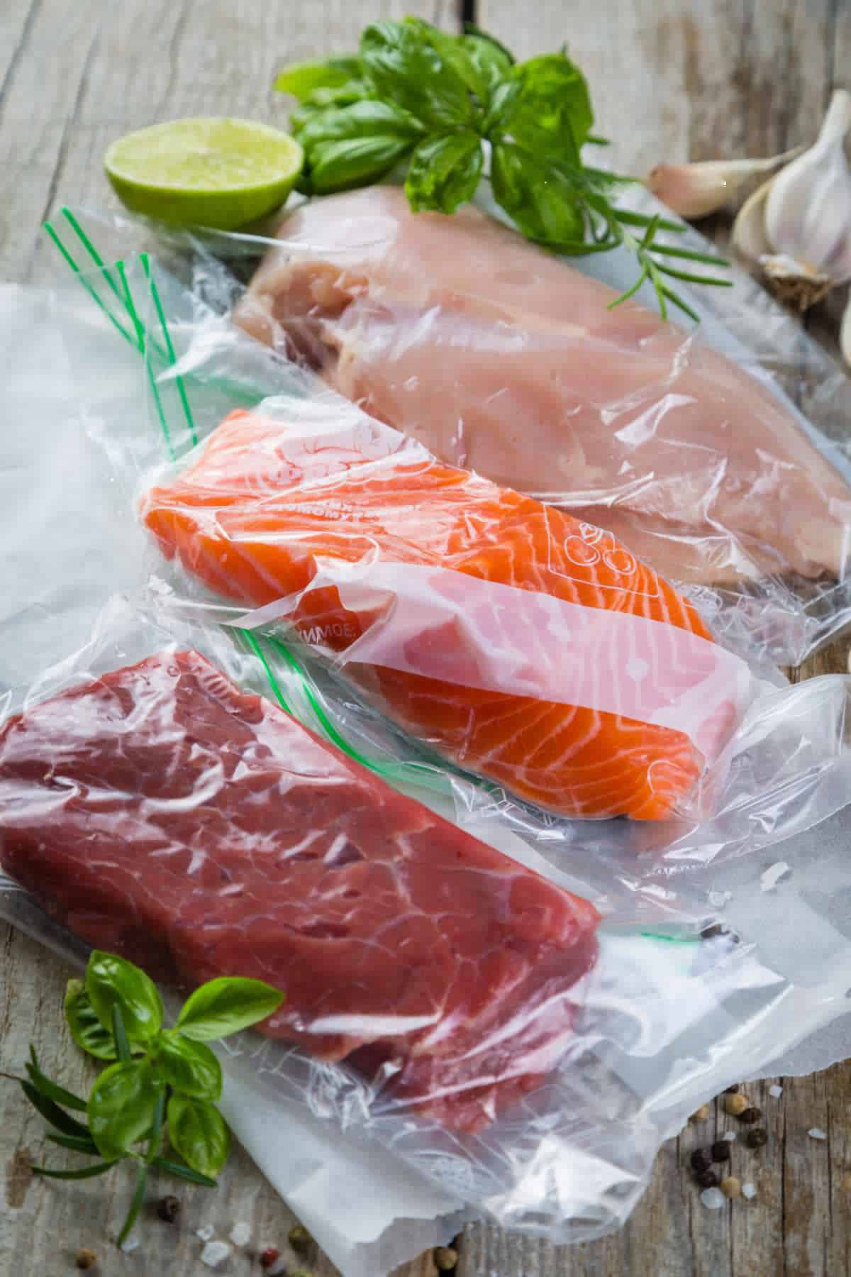 Beef, chicken and salmon in vacuum plastic bag for sous vide cooking.