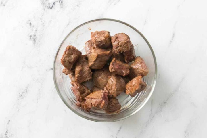 Cooked steak pieces in a glass bowl ready for steak quesadillas.