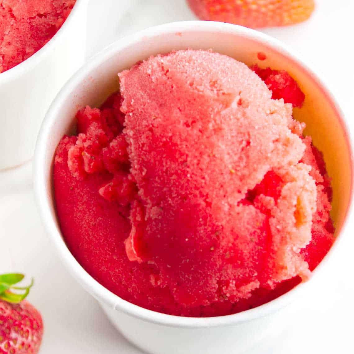 Strawberry sorbet in ice cream storage tubs.
