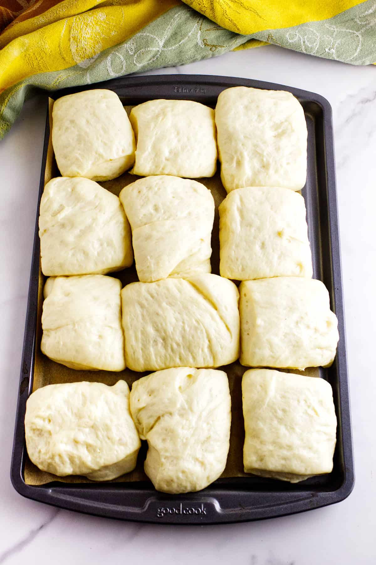 Shaped rolls rising on baking sheets before baking.