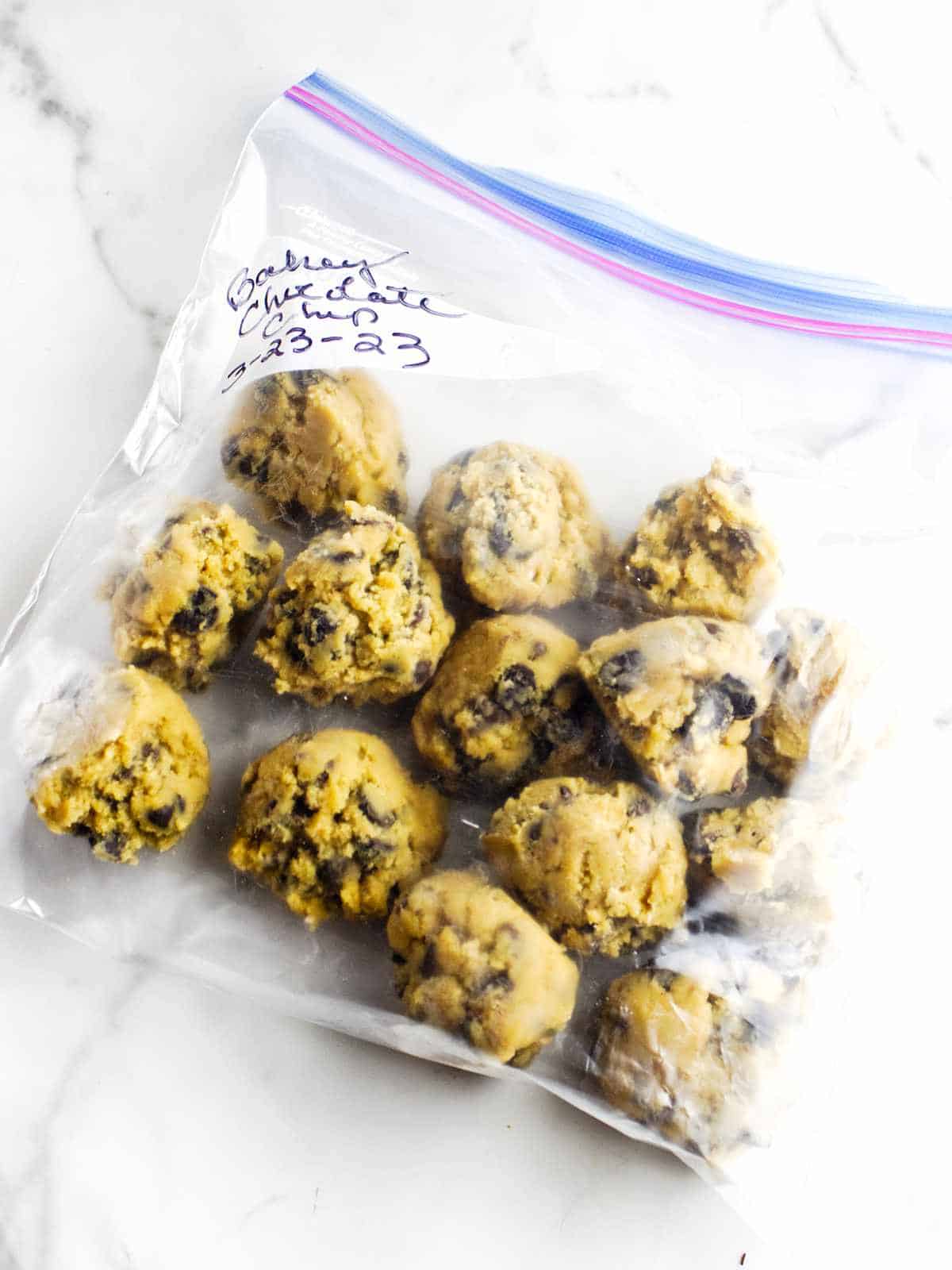 freezer bag full of frozen bakery style chocolate chip cookies for storing in the freezer.