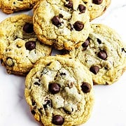 Bakery style chocolate chip cookies on a white marble background.