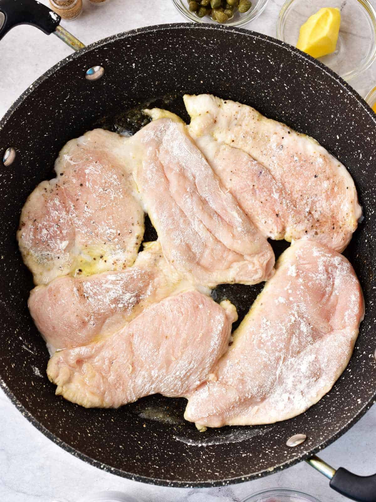 floured chicken browning in a skillet.