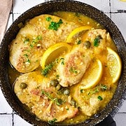 cast iron skillet with chicken with lemon and capers.