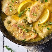cast iron skillet with chicken with lemon and capers.