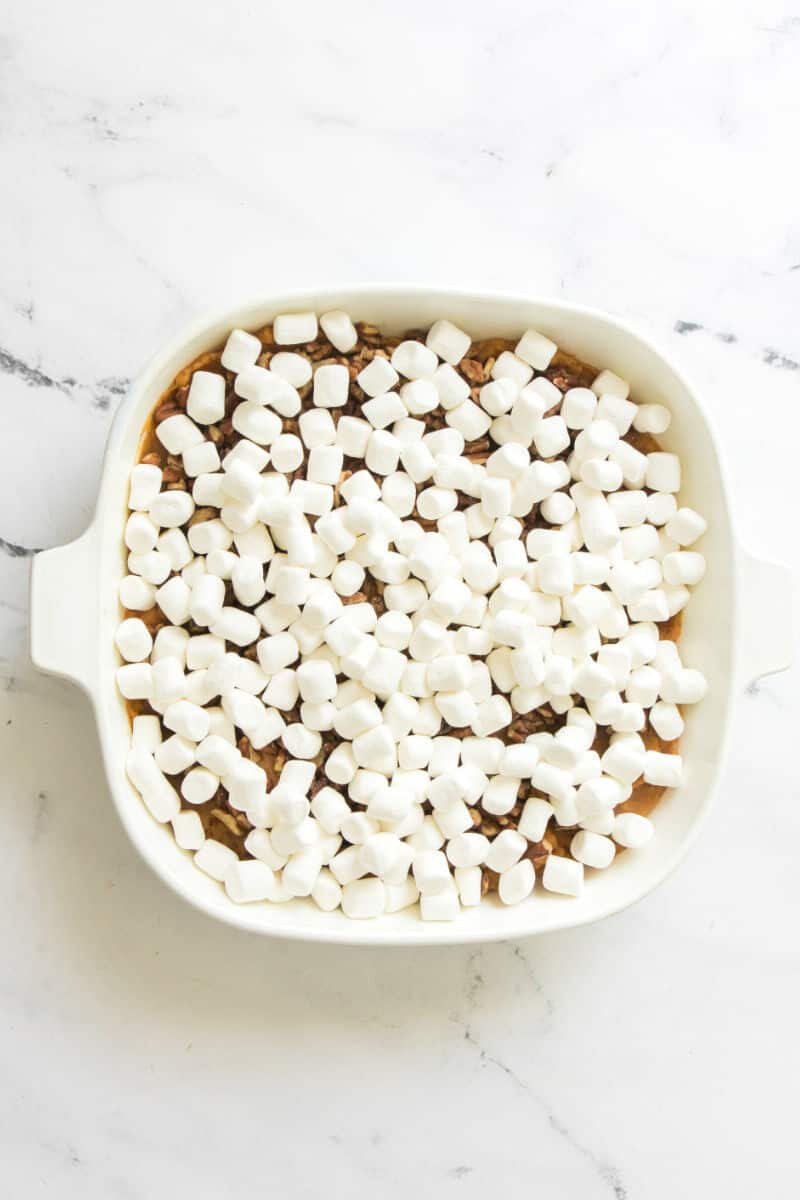 mini marshmallows on top of pecans in a casserole.