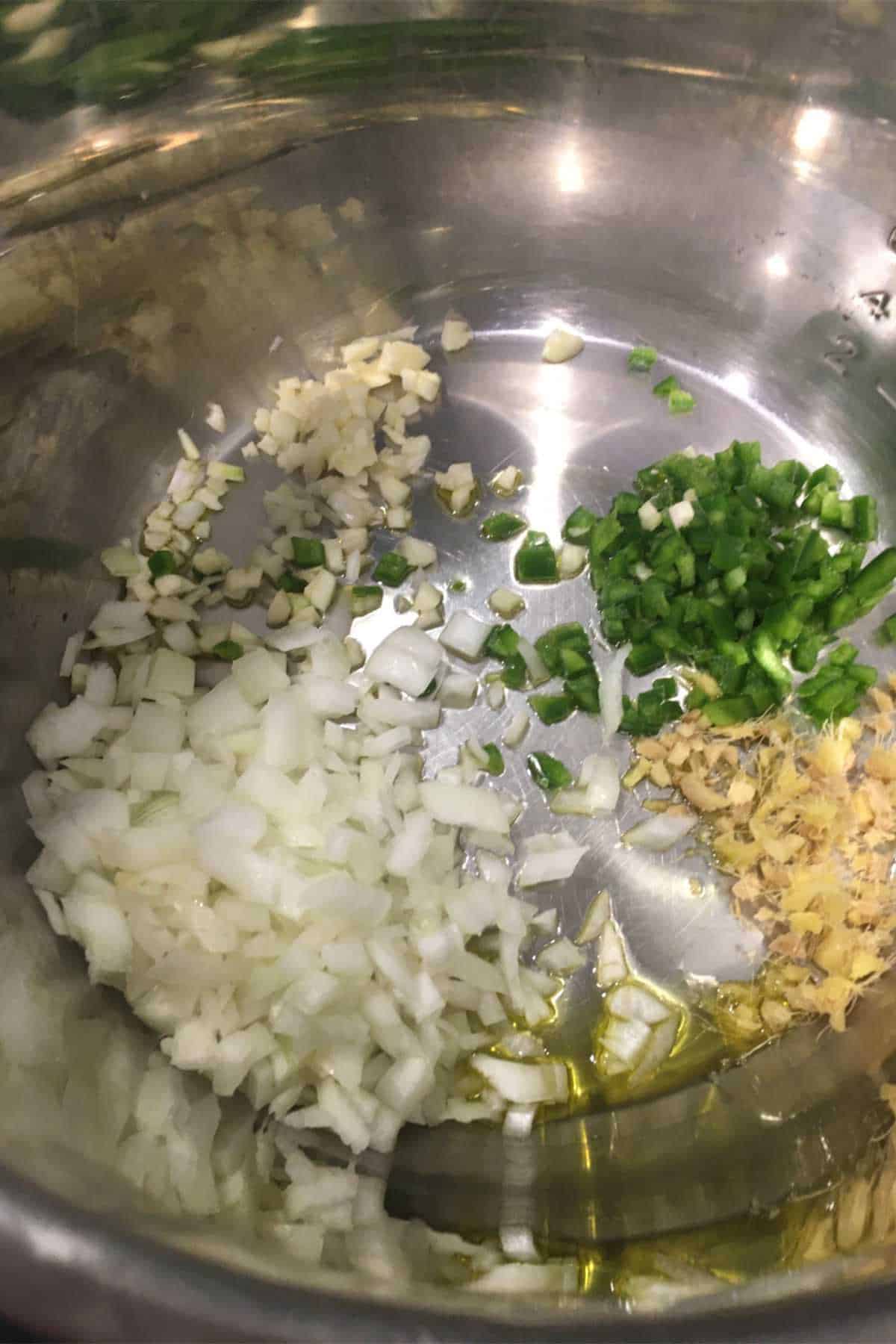 onion, garlic, jalapeno, and ginger sauteing with olive oil in an instant pot.