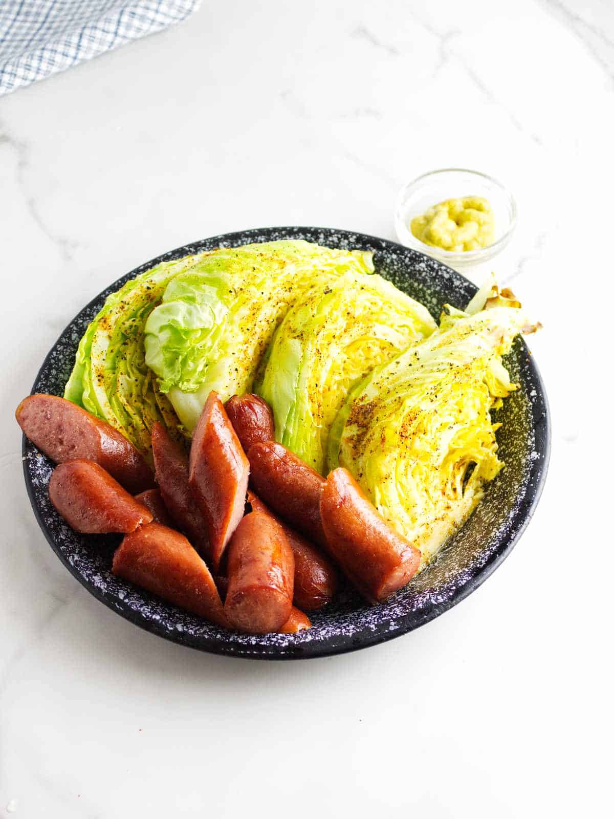 air fryer cabbage on a plate with sausage chunks.