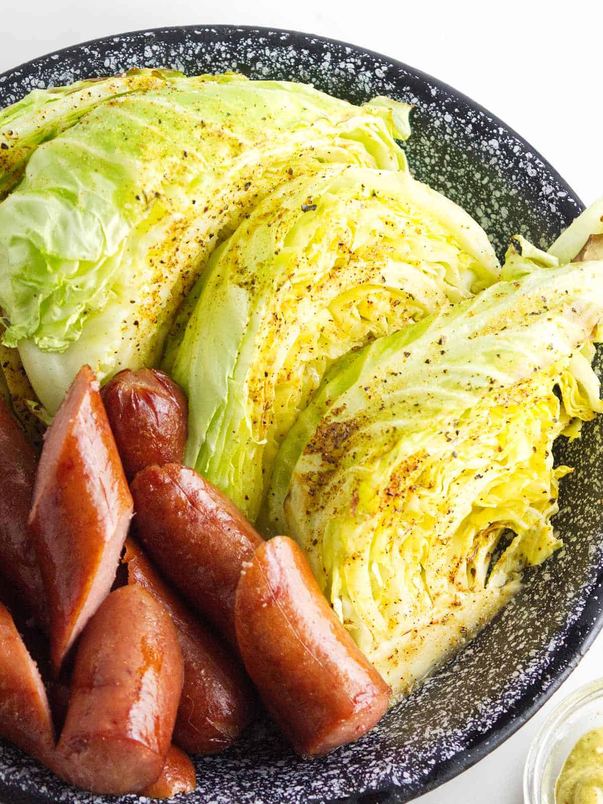 air fryer cabbage on a plate with sausage chunks.