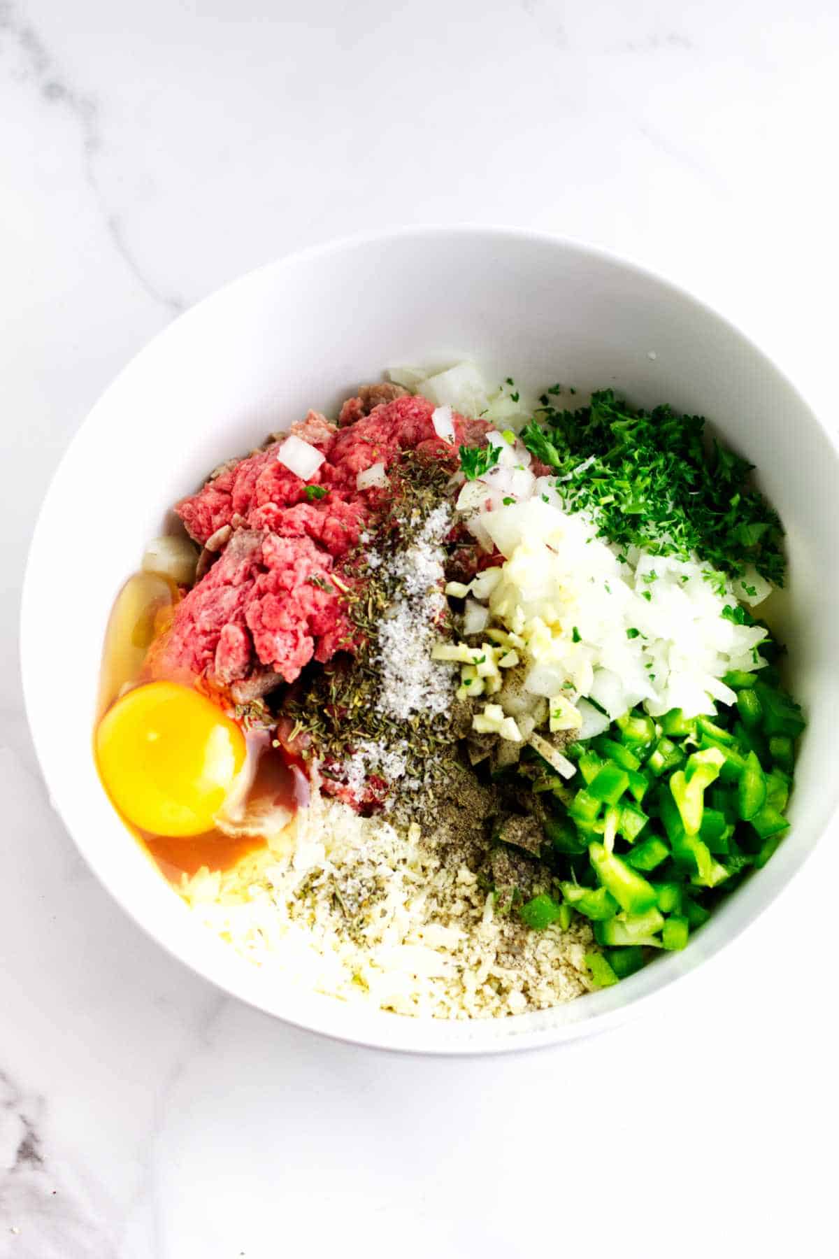 ground beef, egg, bread crumbs, and seasonings in a bowl.