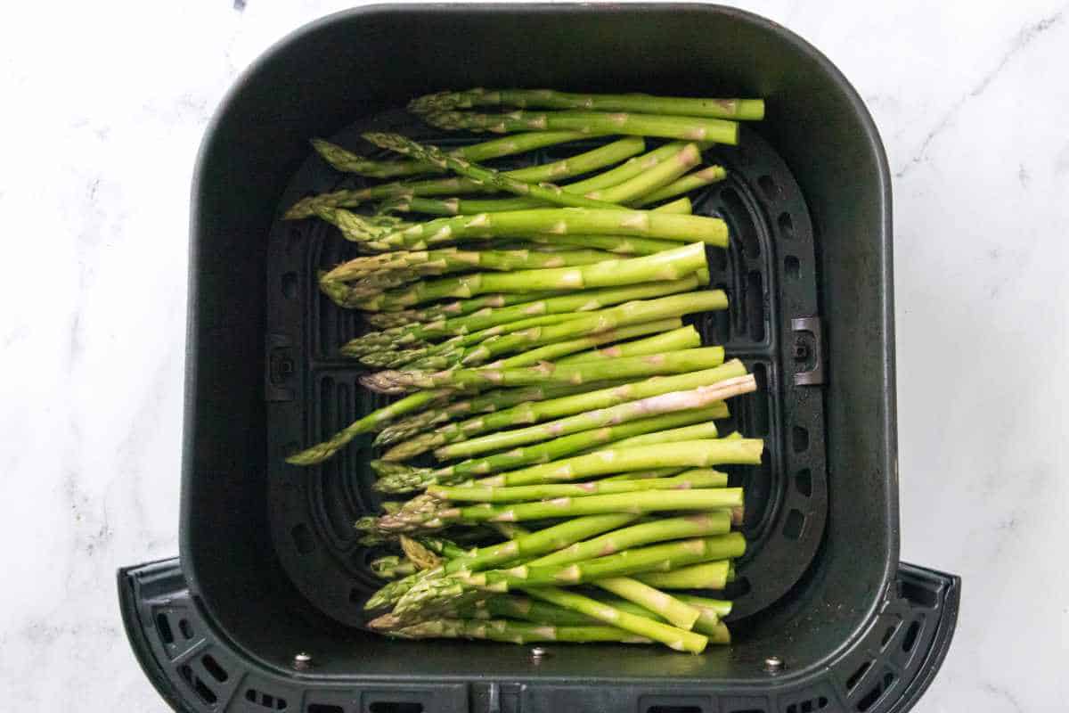 fresh washed and trimmed asparagus in the bottom of cooking basket.