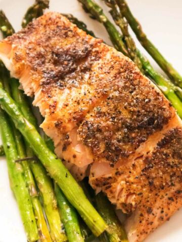 plate of salmon and asparagus on a white background.