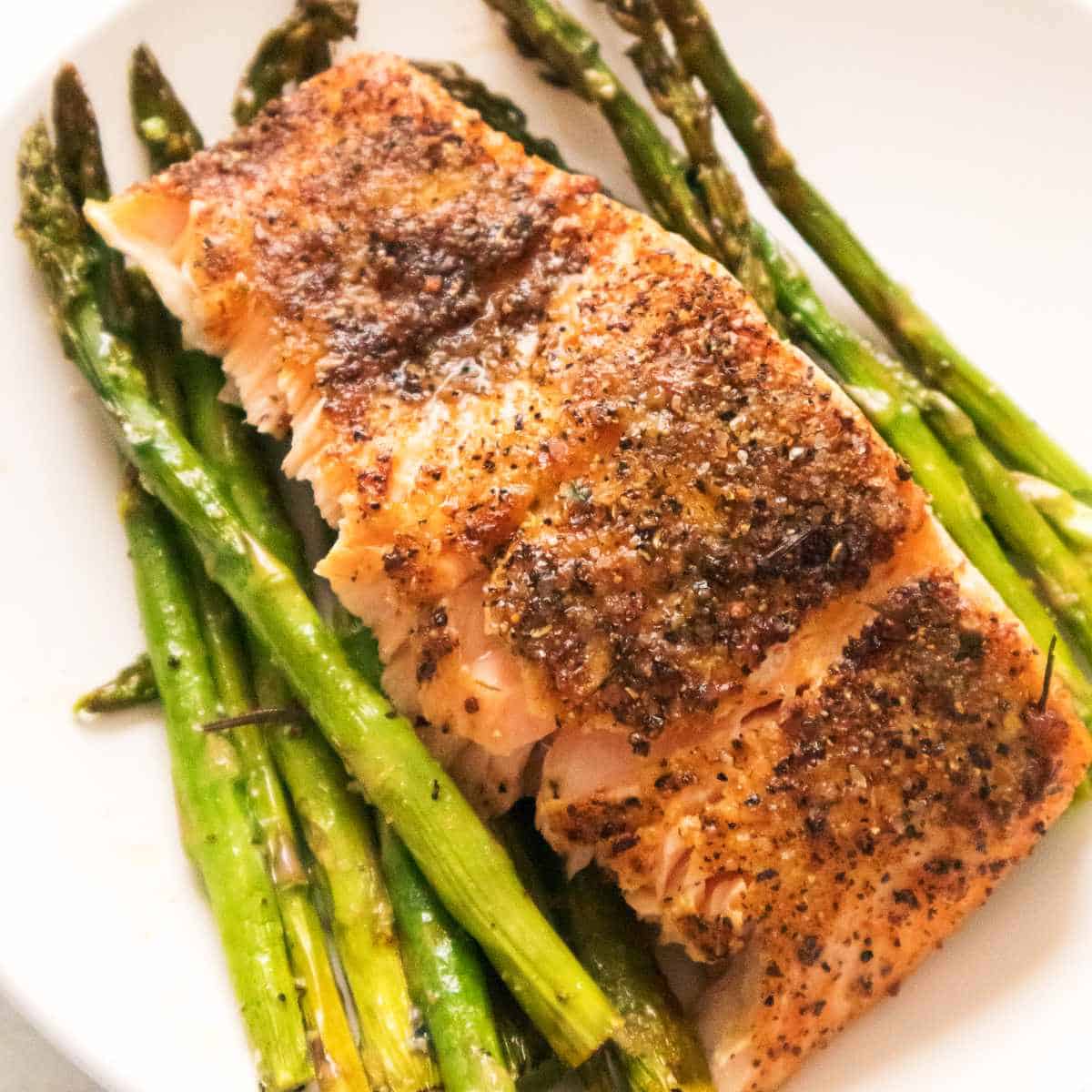plate of salmon and asparagus on a white background.