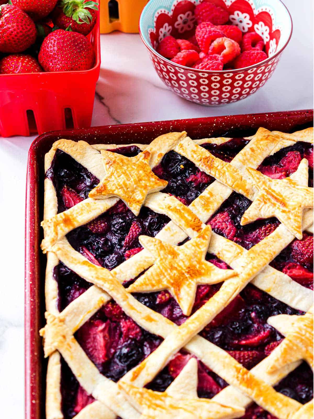 berry slab pie with crisscross top crust and decorative stars.