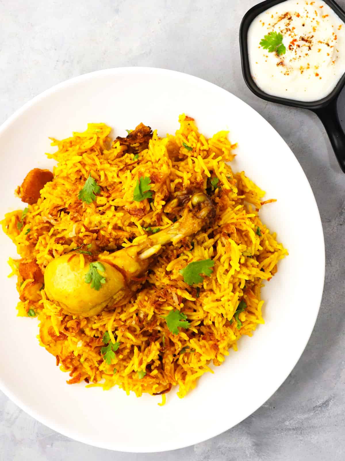 plate with serving of chicken biryani and rice.