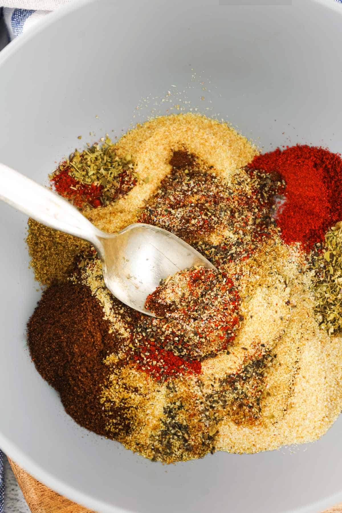 spoon blending spices in a bowl.
