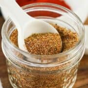 spoonful of chicken taco seasoning blend over a mason canning jar and lid.