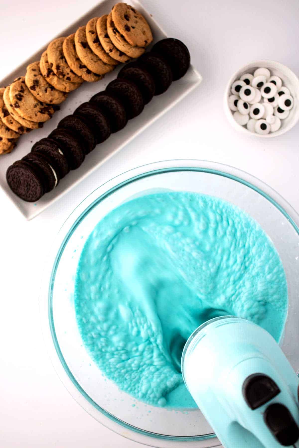 Mixer blending blue contents in a bowl.