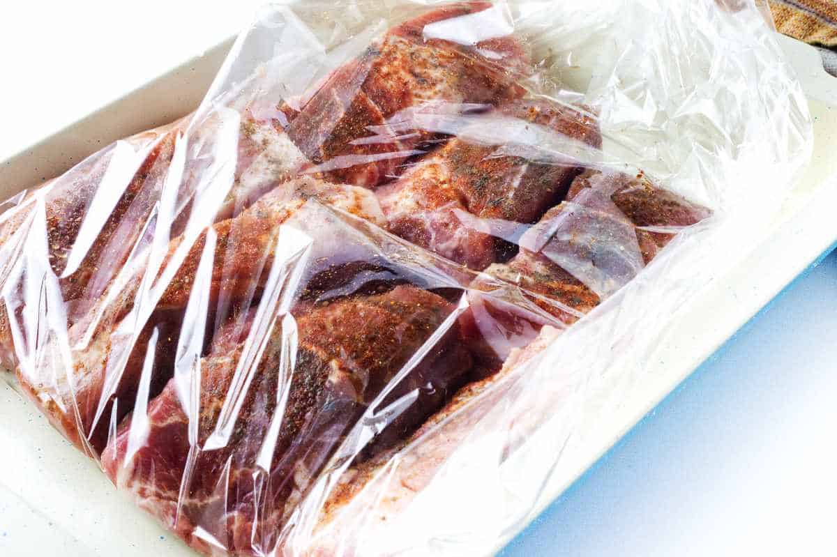raw boneless pork ribs in roasting bag in a roasting pan