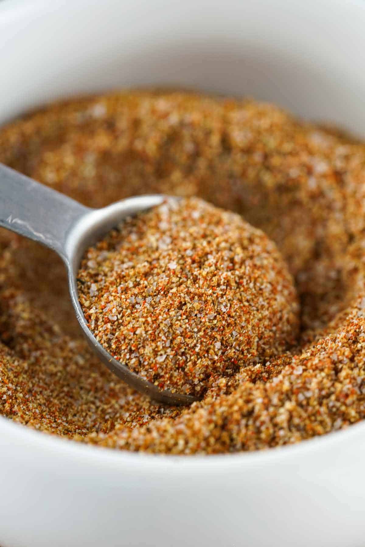 measuring spoon in a bowl of mixed spices.