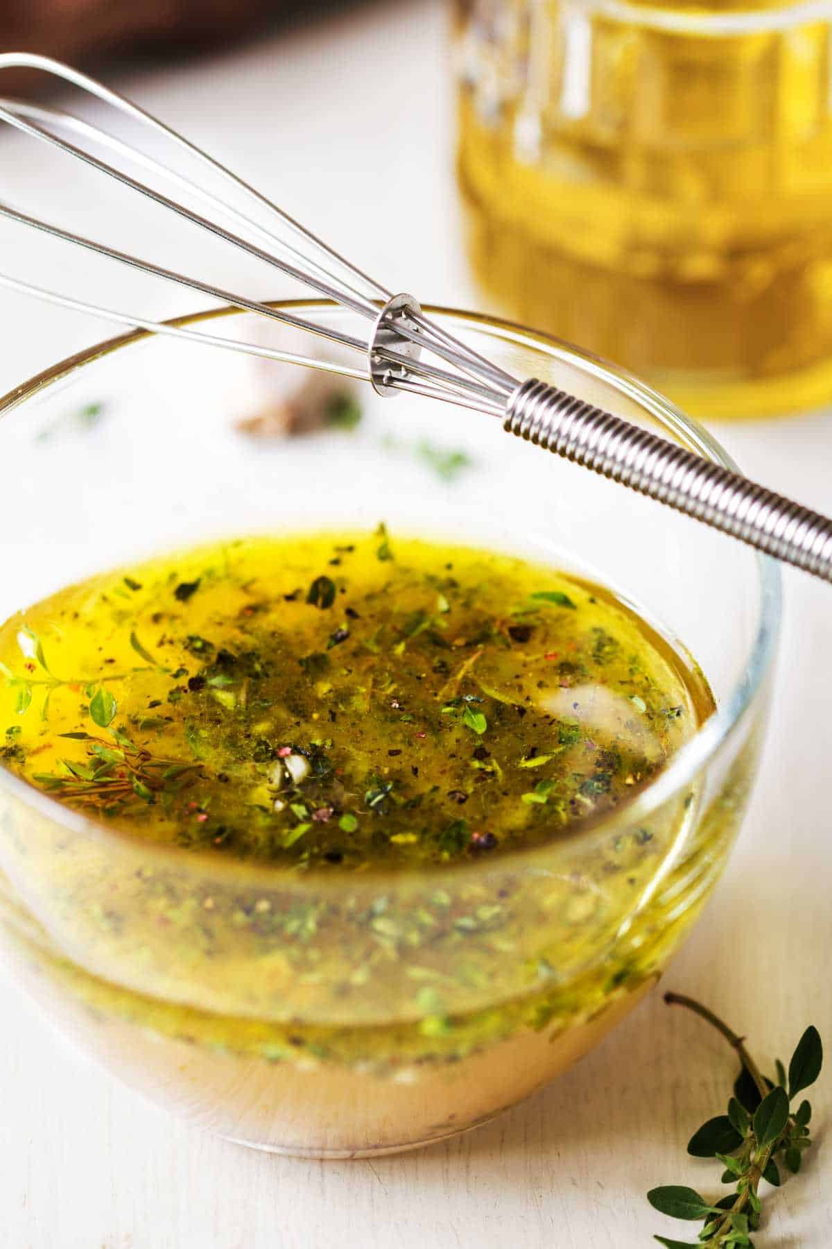 whisk and a bowl of white balsamic dressing.
