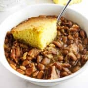 bowl of ham and beans with cornbread on top.