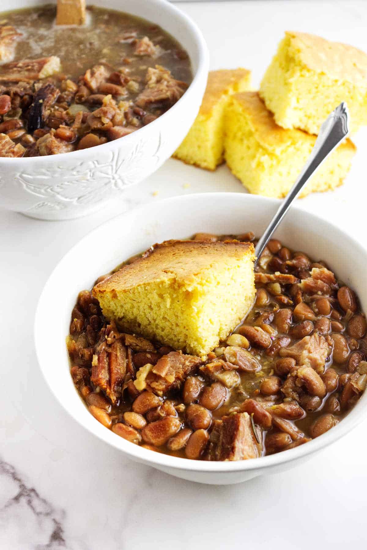 bowl of ham and beans with cornbread on top.