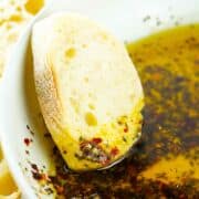 crusty bread getting dipped into oil and spices.