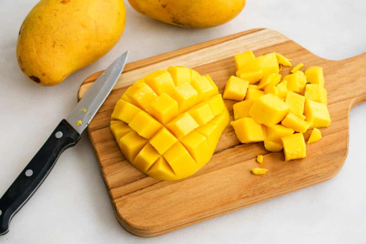 cutting ripe mangoes for making a magonada.