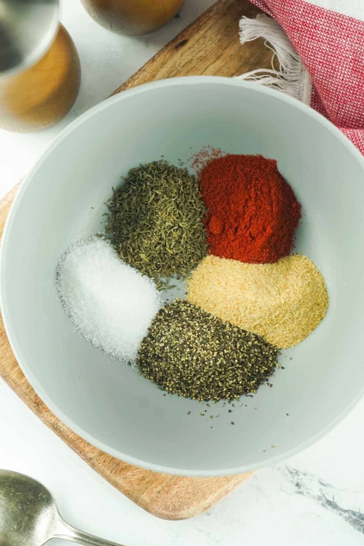five colorful spices added to a bowl.