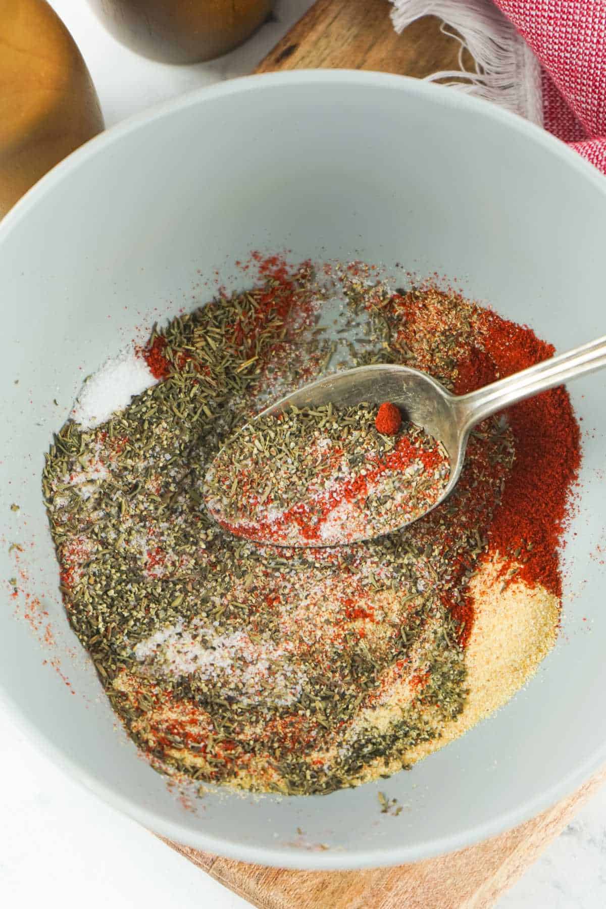 spoon blending spices together in a bowl.