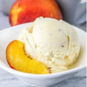 bowl of peach ice cream with slices of peach.