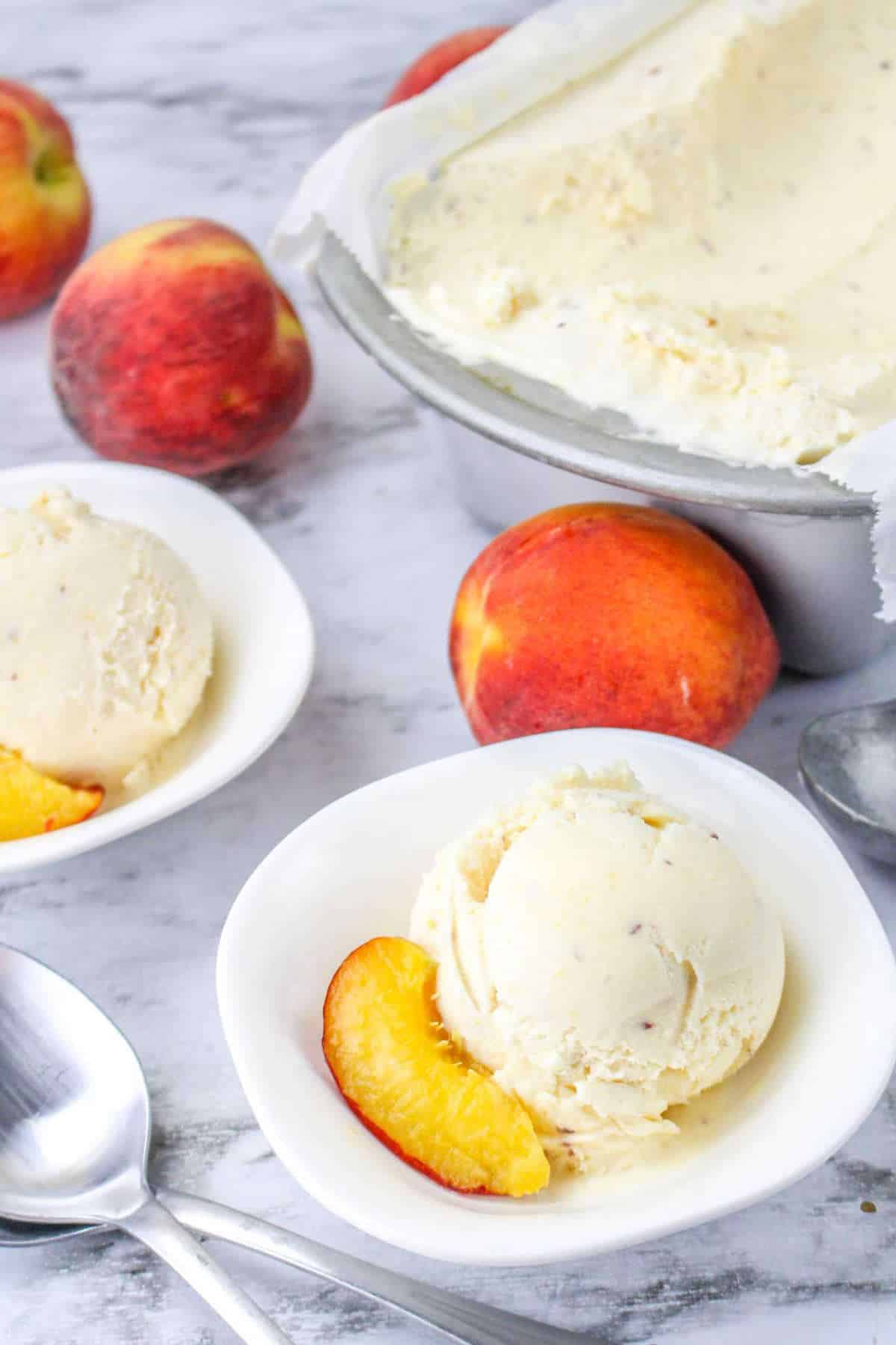 pan of chilled frozen dessert with peaches and scoops in bowls.